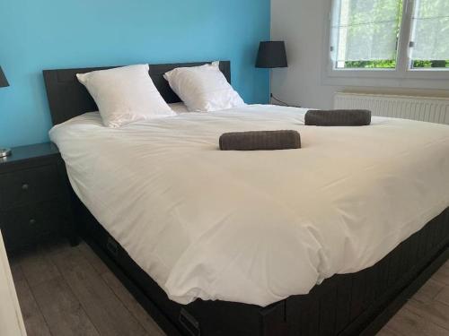a large bed with white sheets and pillows on it at Petite maison en Auvergne in Giat