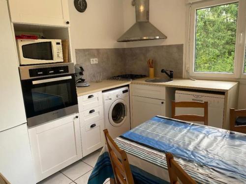 a kitchen with a stove top oven and a microwave at Petite maison en Auvergne in Giat