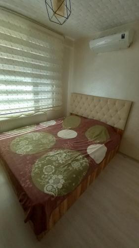 een groot bed in een kamer met een raam bij Çekirge Apart 5 in Çekirge