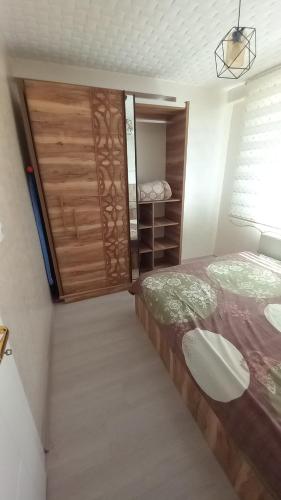 a small bedroom with a bed and a wooden door at Çekirge Apart 5 in Çekirge