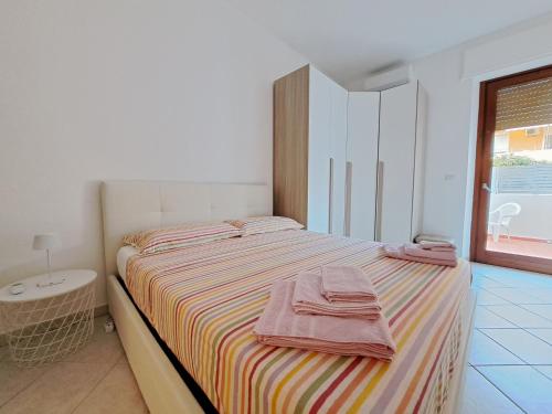 una camera da letto con un letto con asciugamani sopra di Logudoro Home ad Alghero