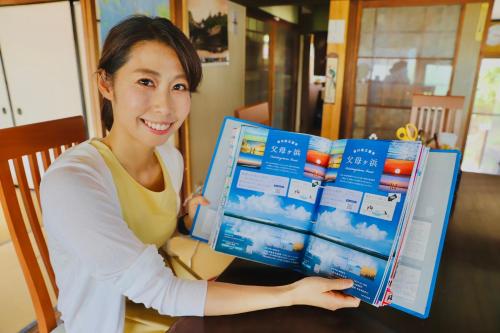a woman sitting at a table holding a box of clouds at まんのう清流庵 in Manno
