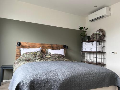 Schlafzimmer mit einem Bett mit einem Kopfteil aus Holz in der Unterkunft Flowerbed in Voorhout