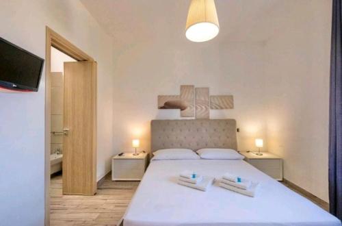 ein Schlafzimmer mit einem großen weißen Bett mit zwei Kissen in der Unterkunft B&B Corte Salentina in Taviano