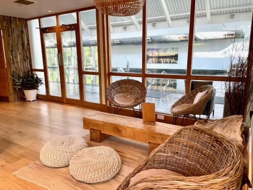 a living room with chairs and a coffee table at Cosy Cotswold Lodge by Your Home Here - SUMMER SALE for 3 PLUS NIGHTS - ideal for families with log-burner, spa, private parking, EV recharging and heated swimming pools in Ashton Keynes