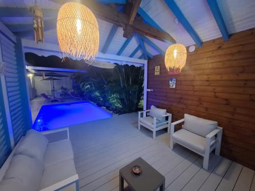 a patio with a swimming pool and two chandeliers at RIVER PARADISE in Goyave