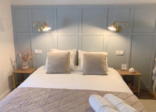 ein Schlafzimmer mit einem großen Bett mit weißer Bettwäsche und Kissen in der Unterkunft Lujoso apartamento boutique a estrenar con parking gratis in Gijón