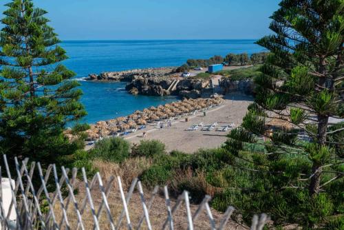 a view of a beach with a fence and the ocean at Naiada Stomio-B apartment in Katsímbalis