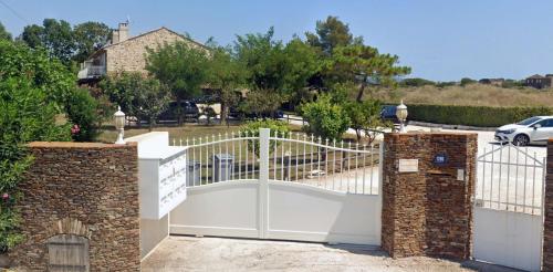 une clôture blanche avec un portail dans une allée dans l'établissement Grand Studio à 5mns de la Plage des Salins, à Hyères
