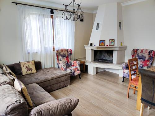 a living room with a couch and a fireplace at Терасите - Къща 2 in Ribarica
