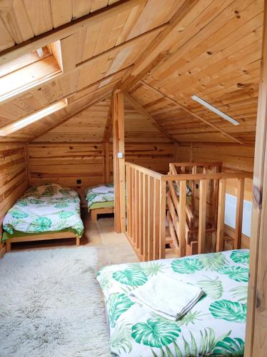 a room with two beds in a wooden cabin at Терасите - Къща 2 in Ribarica