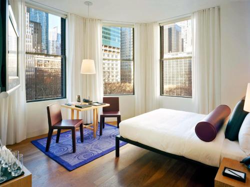 um quarto com uma cama e uma mesa com cadeiras em Bryant Park Hotel em Nova Iorque