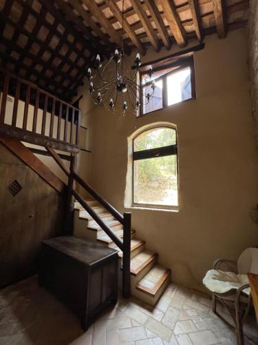 a staircase in a room with a window and a chandelier at Can Maimes in Agullana