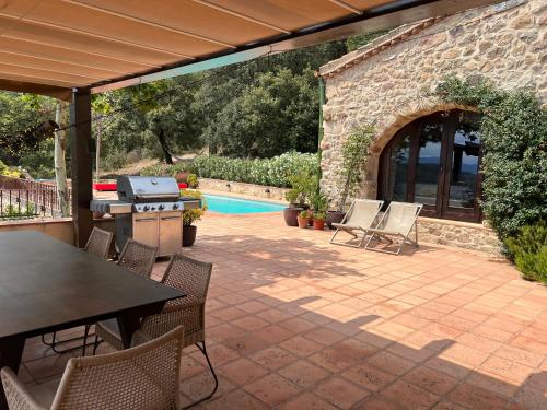 a patio with a table and chairs and a pool at Can Maimes in Agullana