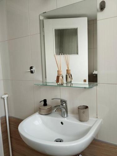 a bathroom with a white sink and a mirror at Vicky's central apartment in Korinthos