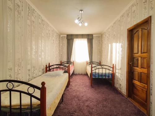 a bedroom with two beds and a window at Адилет in Cholpon-Ata