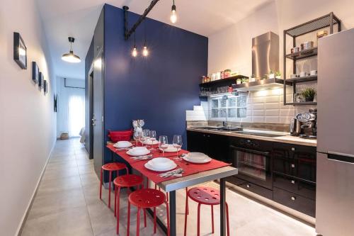 eine Küche mit einem Tisch mit roten Stühlen in der Unterkunft Home Cinema at the center of Thessaloniki in Thessaloniki
