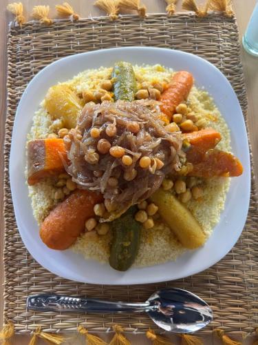 a plate of food with meat and vegetables on a table at Tazart Lodge in Marrakech
