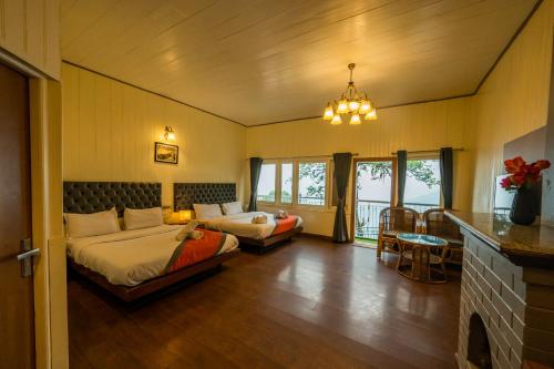 a bedroom with two beds and a chandelier at Arcadia Heritage Resort in Darjeeling