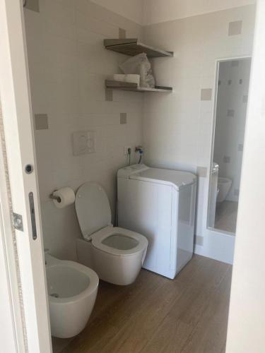 a white bathroom with a toilet and a sink at Interno H10 - Olimpia Residence in Policoro