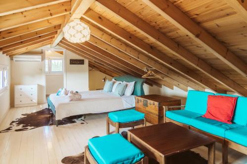 a bedroom with a bed and two blue chairs at Villa Kira in Áfra