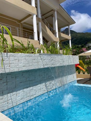 a swimming pool in front of a house at Tropical Hideaway in Beau Vallon