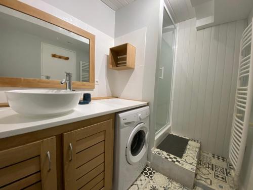 a bathroom with a sink and a washing machine at le refuge de Majèle 