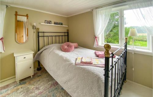 Un dormitorio con una cama con almohadas rosas y una ventana en 3 Bedroom Nice Home In Fjrs, en Fjärås