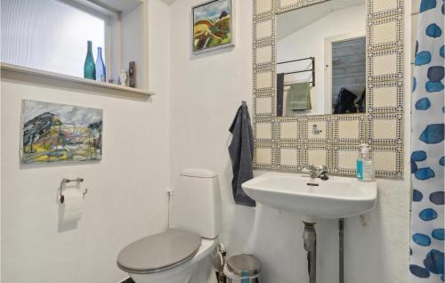 y baño con aseo blanco y lavamanos. en Amazing Home In Blokhus With House Sea View, en Blokhus