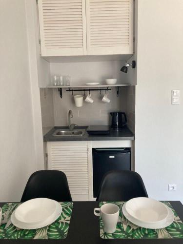 a kitchen with a table and two chairs with plates on it at Apartamenty Familijne w Dąbkach in Dąbki