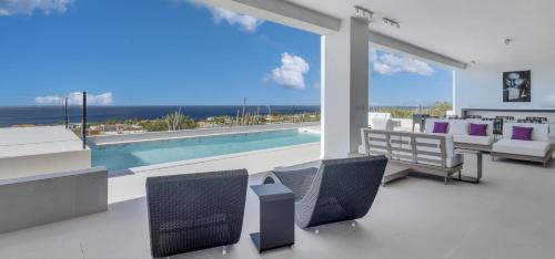 a living room with a swimming pool and chairs at Villa Regatta in Hato