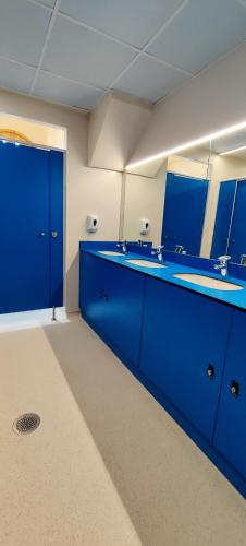 ein blaues Badezimmer mit zwei Waschbecken und einem Spiegel in der Unterkunft Alberg Cabrera de Mar Xanascat in Cabrera de Mar