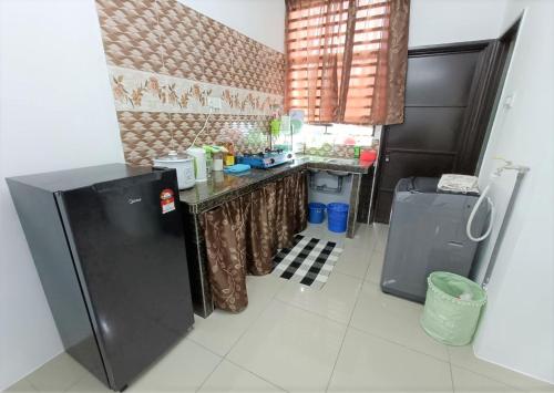 a kitchen with a refrigerator and a counter top at Mira Homestay Gurun - Pendang in Pendang