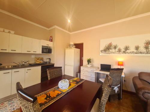 a kitchen and dining room with a table and chairs at Firefly Cottage: Cosi nest tucked away in garden in Kenton on Sea