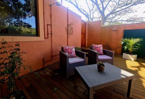 a patio with two chairs and a table at Firefly Cottage: Cosi nest tucked away in garden in Kenton on Sea