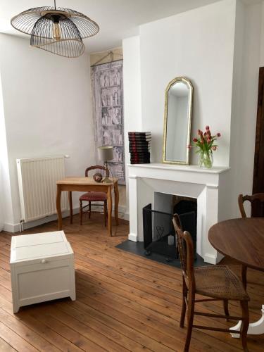 a living room with a fireplace and a mirror at Un Petit Château in Lauzun