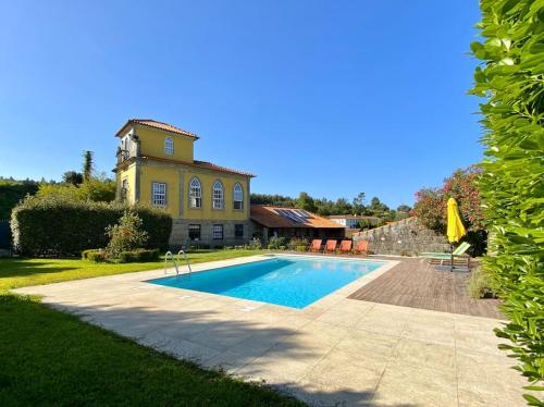 a house with a swimming pool in front of a house at Casa do Mirante in Croca