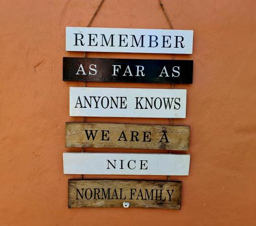 a group of signs hanging on a wall at Firefly Cottage: Cosi nest tucked away in garden in Kenton on Sea