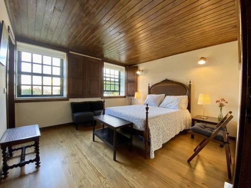 a bedroom with a bed and a wooden ceiling at Casa do Mirante in Croca