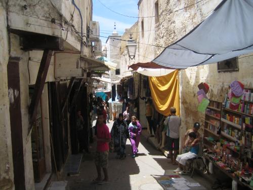a group of people walking down a street in an alley at DAR SEFFAH au cœur de la Médina in Fès
