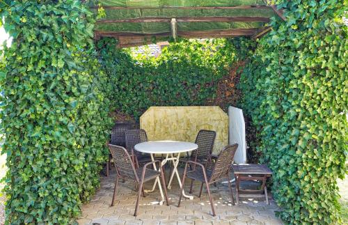 a table and chairs sitting under an ivy covered wall at Villa Vili - Jacuzzi, BBQ & EV Outlet in Limbuš