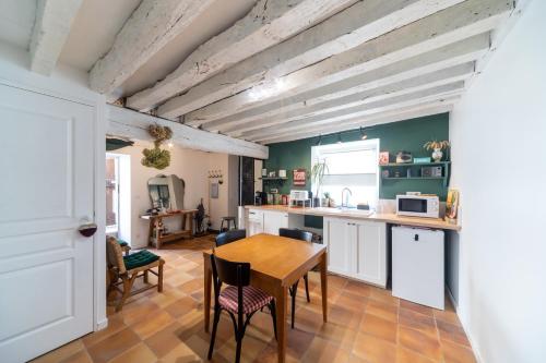 uma cozinha e sala de jantar com mesa e cadeiras em Le Clos de la Tour 