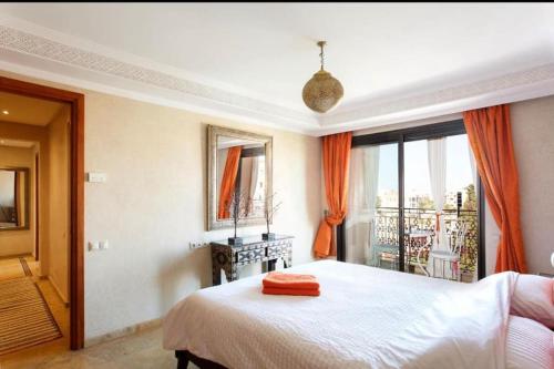 馬拉喀什的住宿－The Jade Apartment，一间卧室配有带橙色窗帘的大床