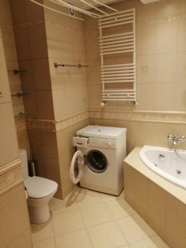 a bathroom with a washing machine and a sink at Tylko dla Orłów in Warsaw
