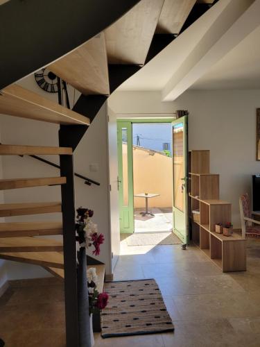 a living room with a staircase and a view of the beach at Gîte l'atelier de Phil et Delfe in Sainte-Cécile-les-Vignes