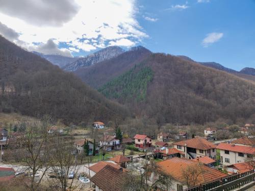 a town in front of a mountain range with houses at Терасите - Къща 3 in Ribarica