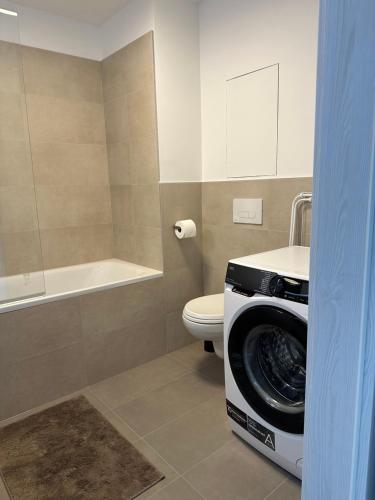 uma casa de banho com uma máquina de lavar roupa e um WC em 2 room Apartment, new building, near Airport, Ovocné sady, em Prievoz