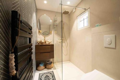 a bathroom with a glass shower and a mirror at Golfe de St Tropez 3 pièces jardin piscine privée in Sainte-Maxime
