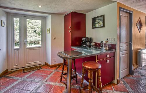 a kitchen with red cabinets and a counter top at Cozy Home In Augignac in Augignac