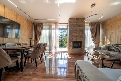 a living room with a table and chairs and a couch at MONTE PINE CHALETS in Žabljak